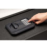 Image of SnapSafe Trunk Safe II keypad with a hand inputting the security code for easy access and protection of valuables.